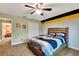 Bedroom with ceiling fan, tan walls, and sports themed bedding and decor at 5479 Saint Regis Way, Port Orange, FL 32128