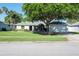 A well-maintained single-Gathering home with a manicured lawn and mature trees at 5479 Saint Regis Way, Port Orange, FL 32128