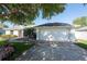A well-lit two-car garage is attached to this single Gathering home with mature landscaping at 5479 Saint Regis Way, Port Orange, FL 32128