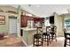 Well-lit kitchen with dark wood cabinetry, stainless steel appliances, granite countertops, and bar stool seating at 5479 Saint Regis Way, Port Orange, FL 32128