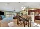 Open-concept living room and kitchen with tile floors, bar seating, and natural light from sliding glass doors at 5479 Saint Regis Way, Port Orange, FL 32128