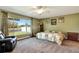 Tranquil main bedroom with large window overlooking the lake and featuring an upholstered armchair at 5479 Saint Regis Way, Port Orange, FL 32128