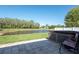 Outdoor patio featuring a hot tub overlooking a pond surrounded by lush green grass and trees at 5479 Saint Regis Way, Port Orange, FL 32128