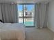 Bedroom with sliding glass doors to patio and view of the community swimming pool at 5500 Ocean Shore Blvd # Ut18, Ormond Beach, FL 32176
