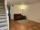 Comfortable living room with tile flooring, staircase, and a cozy brown couch, perfect for relaxation at 5500 Ocean Shore Blvd # Ut18, Ormond Beach, FL 32176