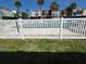 View of the community pool surrounded by lush landscaping and a white fence, creating a tranquil and inviting atmosphere at 5500 Ocean Shore Blvd # Ut18, Ormond Beach, FL 32176