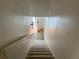Carpeted stairway leading to a tiled area with natural light streaming through a doorway at 5500 Ocean Shore Blvd # Ut18, Ormond Beach, FL 32176