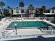View of large community pool with lounge chairs surrounded by palm trees at 5500 Ocean Shore Blvd # Ut18, Ormond Beach, FL 32176