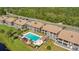 Aerial view of condos with community pool, cabana, and well-maintained landscaping at 563 Belltower Ave # 240, Deltona, FL 32725