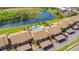 Aerial view of condos with pool, landscaping, covered parking, and water view at 563 Belltower Ave # 240, Deltona, FL 32725