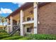 Condo exterior featuring outdoor patios, stairs, covered entry, and mature landscaping at 563 Belltower Ave # 240, Deltona, FL 32725