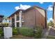 Two-story brick condo building with walkways, manicured landscaping, and a sunny sky at 563 Belltower Ave # 240, Deltona, FL 32725