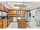 Open kitchen with stainless steel appliances, natural wood cabinets, tiled backsplash and an island at 563 Belltower Ave # 240, Deltona, FL 32725