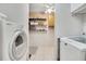 Laundry room featuring white washer and dryer, a ceiling fan, storage shelves and cabinets at 563 Belltower Ave # 240, Deltona, FL 32725