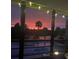 Outdoor pool overlooks lake with sunset views and string lights on the lanai at 563 Belltower Ave # 240, Deltona, FL 32725