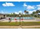 Community pool with lounge chairs, mature landscaping, and a bright blue sky at 563 Belltower Ave # 240, Deltona, FL 32725