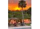 Stunning sunset view over the lake, enjoyed from the outdoor patio with seating area at 563 Belltower Ave # 240, Deltona, FL 32725