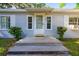 Inviting front entrance with wooden steps, a covered porch and a white trimmed door at 607 Herbert St, Port Orange, FL 32129