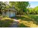 Charming backyard shed surrounded by lush greenery, offering practical storage in a picturesque setting at 607 Herbert St, Port Orange, FL 32129