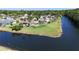 Aerial view of a waterfront property with a home, mature landscaping, and large backyard at 6182 Knotty Pine Ct, Port Orange, FL 32127