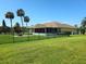 A large fenced-in backyard with a screened in patio and lush green grass at 6182 Knotty Pine Ct, Port Orange, FL 32127