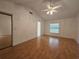This bedroom has a ceiling fan, wood flooring, and a big window with a view at 6182 Knotty Pine Ct, Port Orange, FL 32127