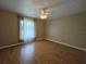 This bedroom has a ceiling fan and a window with views of the home's property at 6182 Knotty Pine Ct, Port Orange, FL 32127
