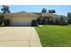 A well-maintained home with a two-car garage, a driveway and a large grassy front yard at 6182 Knotty Pine Ct, Port Orange, FL 32127