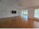 Spacious living room with hardwood floors, ceiling fan, and view into the sunroom at 6182 Knotty Pine Ct, Port Orange, FL 32127