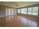 Bright sunroom with hardwood floors, ceiling fan, and several windows with views of the backyard at 6182 Knotty Pine Ct, Port Orange, FL 32127