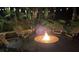 Well-lit outdoor fire pit area with seating surrounded by lush landscaping, perfect for entertaining or relaxing at 6194 Half Moon Dr, Port Orange, FL 32127