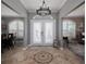 Grand foyer with beautiful tile flooring, arched windows with white shutters and decorative lighting at 6194 Half Moon Dr, Port Orange, FL 32127