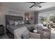 Elegant main bedroom with stylish furniture, modern ceiling fan, and access to outdoor pool and patio area at 6194 Half Moon Dr, Port Orange, FL 32127