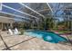Enjoy this screened-in pool with chairs and tables perfect for relaxing or entertaining guests on a sunny day at 6194 Half Moon Dr, Port Orange, FL 32127