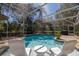 Inviting pool area with in-pool seating and screened enclosure, surrounded by lush landscaping at 6194 Half Moon Dr, Port Orange, FL 32127