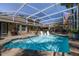 View of the in-ground pool with covered patio area, grill, and view of the house at 6194 Half Moon Dr, Port Orange, FL 32127