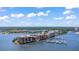 Expansive aerial shot showcasing condo complex surrounded by water and lush greenery under a sunny sky at 761 Marina Point Dr # 7610, Daytona Beach, FL 32114