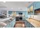 Open kitchen with stainless steel appliances, light blue cabinets, and ample counter space at 761 Marina Point Dr # 7610, Daytona Beach, FL 32114