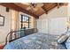 Comfortable main bedroom with vaulted ceilings, wood beam and a blue floral comforter set at 761 Marina Point Dr # 7610, Daytona Beach, FL 32114