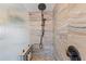 Modern shower featuring bronze fixtures, stone tile walls, and built-in shelving at 761 Marina Point Dr # 7610, Daytona Beach, FL 32114
