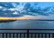 Balcony view featuring a wide river, bridge, and city skyline at sunset under a cloudy sky at 761 Marina Point Dr # 7610, Daytona Beach, FL 32114