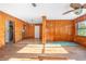 Bright living room with wood-look floors, paneled walls, and a ceiling fan at 816 W Franklin Ave, Deland, FL 32720