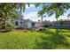 Lush green backyard featuring a patio, deck, and well-maintained lawn with tropical landscaping at 82 Margaret Rd, Ormond Beach, FL 32176