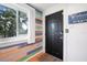 Colorful entryway with stylish black front door and charming coastal decor at 82 Margaret Rd, Ormond Beach, FL 32176