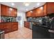 A modern kitchen features tile floors, wood cabinets, and stainless steel appliances at 82 Margaret Rd, Ormond Beach, FL 32176