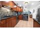 Well-equipped kitchen featuring wood cabinetry, stainless steel appliances, and a mosaic backsplash at 82 Margaret Rd, Ormond Beach, FL 32176