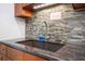 Close up of a kitchen sink with granite countertops and colorful backsplash tiles at 82 Margaret Rd, Ormond Beach, FL 32176