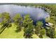 Aerial view of lakefront property with mature trees and a private dock on a serene lake setting at 910 N Kepler Rd, Deland, FL 32724