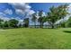 Expansive grassy backyard with mature trees, leading to a picturesque lake view at 910 N Kepler Rd, Deland, FL 32724