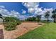Brick paved patio extends into the green lawn, featuring a basketball hoop and a tranquil lake view at 910 N Kepler Rd, Deland, FL 32724